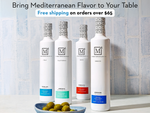 Four bottles of olive oil with labels on a tiled surface, promoting Mediterranean flavor and free shipping.