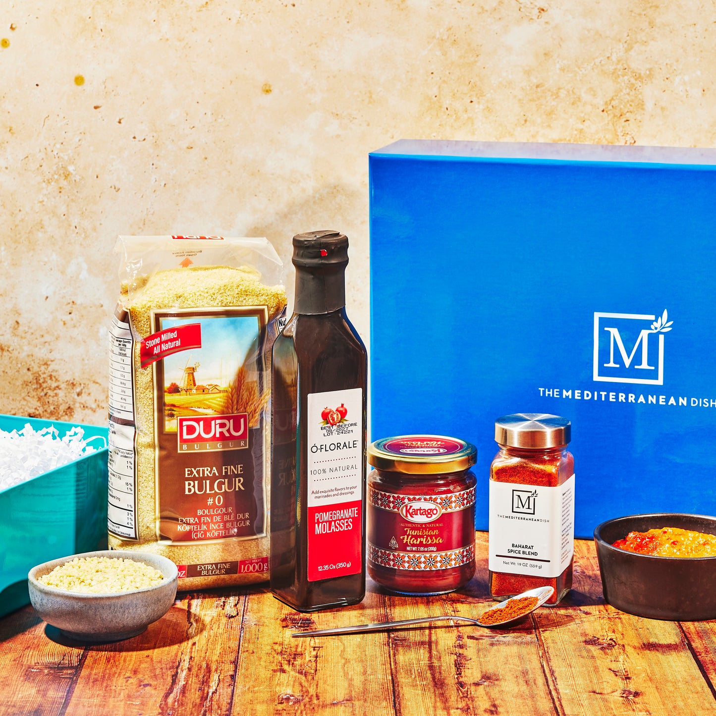 Assorted food items including a box labeled 'The Mediterranean Dish' on a wooden surface.