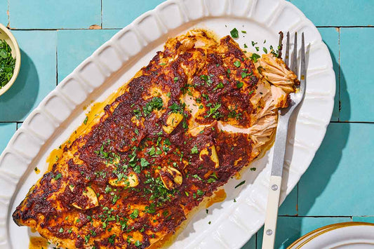 A close up of Turkish style salmon on a serving platter with a fork.