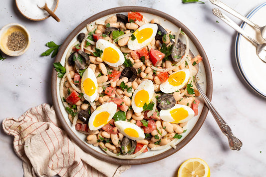 A close up photo of cannellini bean salad on a serving platter with a fork.