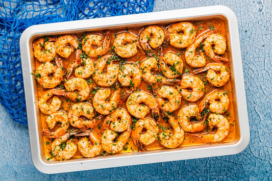 a close up of sheet pan shrimp in sauce.