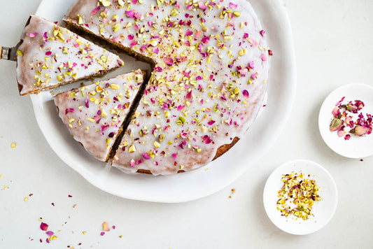 Overhead shot of Persian love cake on a platter with two slices cut out.