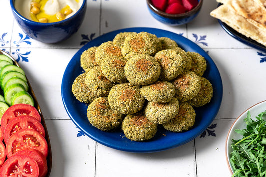A plate of falafel discs stacked on top of each other. 