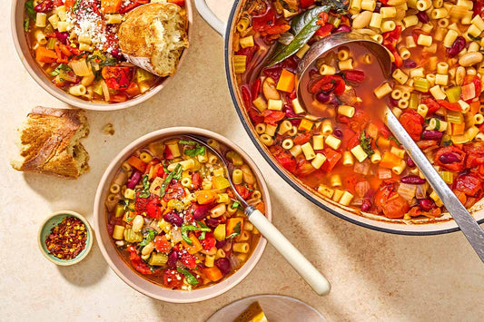 An overhead photo of three bowls filled with pasta fagioli soup.