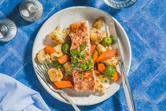 An overhead photo of a salmon filet with roasted vegetables on a dish.