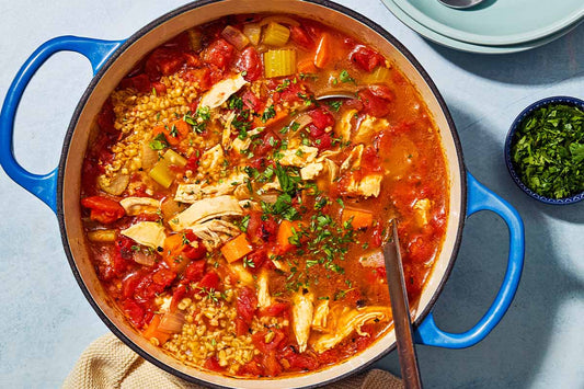 An overhead photo of a large bowl filled with chicken soup and topped with fresh herbs.