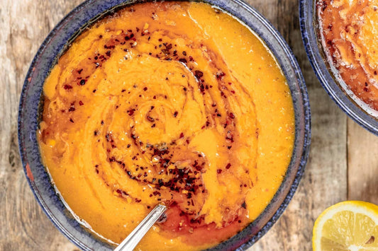 An overhead photo of a bowl filled with red lentil soup.