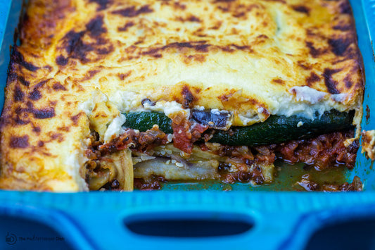 A casserole dish filled with vegetarian moussaka and a slice cut out.