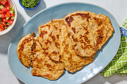 An overhead photo of a serving dish with 4 pieces of stuffed flatbread.