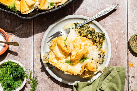 An overhead photo of a plate of spanakopita with a skillet off to the side. 