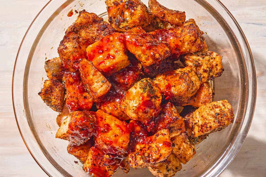 An overhead photo of a bowl of salmon bites covered in seasoning and glaze.