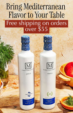 Two bottles of The Mediterranean Dish olive oil on a table with fruits and herbs, promoting Mediterranean flavor and free shipping.