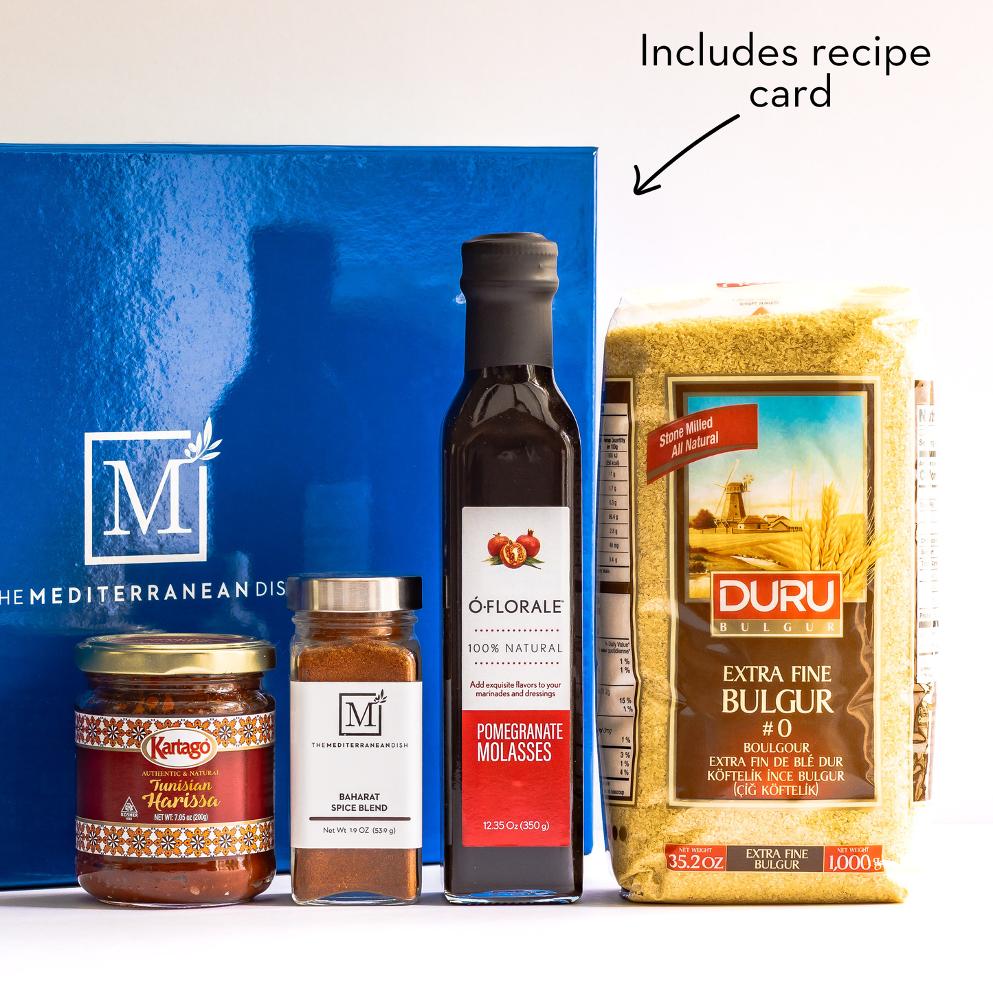Collection of Mediterranean food products including olive oil, spices, and bulgur with a recipe card included.
