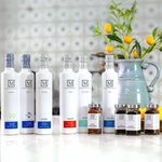 Row of white olive oil bottles with brand logo on a countertop with decorative elements