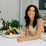 Suzy Karadsheh in a kitchen with a bowl of vegetables and cooking ingredients
