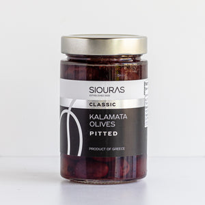 A glass jar of Siouras Classic Kalamata Olives Pitted, featuring a white and black label with a metallic silver lid, set against a clean white background.