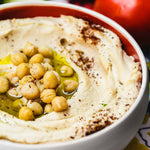 A bowl of hummus with chick peas.